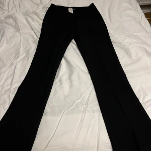 Lågmidjade kostymbyxor - Snygga svarta kostymbyxor från Orsay, lågmidjade och utsvängda! Midjemått: 34cm och innebenslängden:72.5cm