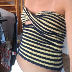 Tubtopp - Säljer en gul/marinblå randig tubtopp från SHEIN, strl. XS. Den har en tvist vid brösten som gör det lilla extra hos toppen💛  Använd max 3 gånger.