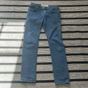 Jacob cohen jeans - Snygga blå jeans från Jacob Cohën med en klassisk femficksdesign och knappgylf. Byxorna har en rak passform och är tillverkade i ett mjukt material för extra komfort. Perfekta för en stilren look. Storlek 30. 