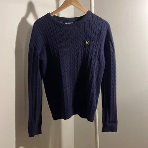 Lyle & Scott tröja  - Marinblå kabelstickad Lyle&Scott tröja storlek 14-15 y/o. Ok skick ca 5/10