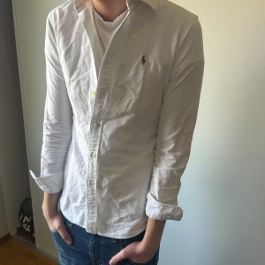 Vit skjorta från Ralph Lauren - Säljer en  vit skjorta från Ralph Lauren i storlek M. Riktigt fräsch till sommaren och den är för liten på mig då jag säljer den, hör av er för frågor!