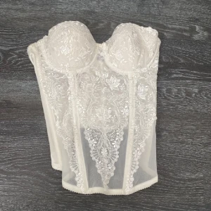 Vit spetskorsett från Salute - Vit korsett från Salute med spetsdetaljering och hakknäppning bak, storlek xs/s💕