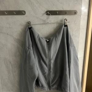 Grå hoodie från Only Trend - Säljer en grå hoodie från Only Trend med dragkedja framtill. Den har en avslappnad passform och en stor huva. Perfekt för en casual look.