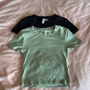 Två t-shirts  - Säljer två t-shirts från H&M i storlek XS. En i svart och en i ljus sagegrön. Perfekta basplagg för vardagsbruk. Båda är cropped och köpta samtidigt. Säljer 1 för 50kr eller båda för 80kr