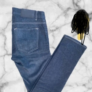 Mörkblå jeans från tiger of Sweden - Snygga mörkblå jeansbyxor med en klassisk femficksdesign. De har en rak passform och är perfekta för en avslappnad stil. Byxorna har en dragkedja och knapp framtill. Från tiger of sweden