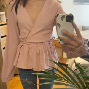 Rosa omlottopp - Säljer en söt ljusrosa omlottblus med longa armar som är perfekt till våren och sommaren! Endast prövad, lapp finns fortfarande kvar❤️ Storlek xs men passar säkert S och xxs. Skriv för fler frågor annars klicka gärna köp❤️🤗 (kan gå ner i pris)
