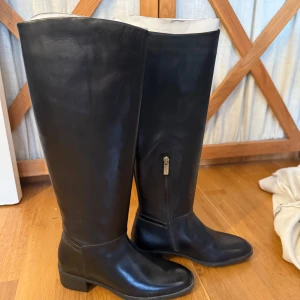 Svarta stövlar från Gant - Snygga svarta stövlar från Gant i skinn med dragkedja på sidan. Perfekta för en stilren look och passar bra till både vardag och fest. De har en låg klack och en klassisk design som aldrig går ur tiden. Använda 2 gånger 