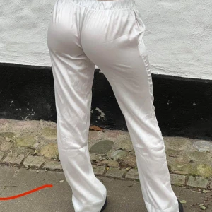 Vita byxor med resårmidja - Design by si byxor, vita satin byxor som sitter perfekt för S. Materialet är mjukt och bekvämt till sommaren. Jag säljer pgr av försmå. (Bilderna är inte mina) men skicka privat för mer bilder 😄