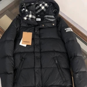 Svart dunjacka från Burberry - Snygg svart dunjacka från Burberry med avtagbara ärmar och huva. Jackan har ett klassiskt rutigt mönster på insidan av huvan och dragkedja samt knappar framtill. Perfekt för kyliga dagar. Man kan båda ha den på sommaren och vinter finns flera färger av burrberry jackan…🙌🏼