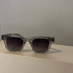 Transparenta solglasögon från Chimi - Snygga transparenta solglasögon från Chimi med fyrkantig form och mörka linser. Perfekta för en stilren look. Jag säljer dessa för att jag inte andvänder dem lika mycket som förut, men jag tycker att de är superfina