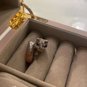 Silverfärgad ring med djurmotiv - Unik silverfärgad ring med ett detaljerat djurhuvud som motiv. Ringen har en glittrig yta på huvudet och en slät, mönstrad banddesign. Perfekt för att ge en lekfull touch till din stil.