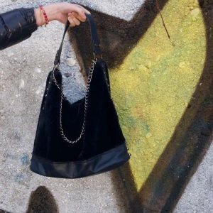 Mörkblå axelväska  - Snygg mörkblå axelväska med kedjedetaljer. Väskan har en stilren design med svarta nitar på sidorna.