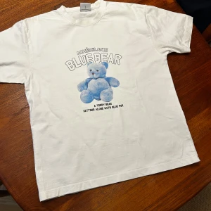 Vit t-shirt med blå nallebjörn  - Säljer dena för att jag använde den inte längre 