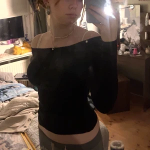 Svart offshoulder topp - Snygg svart offshoulder topp med lång ärm. Perfekt för en stilren look. Passar bra till både jeans och kjol.