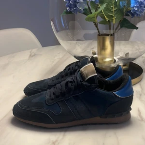 Valentino Rockrunner - Snygga blå sneakers från Valentino med en stilren design. Modellen är rockrunner. De har en klassisk snörning och en bekväm sula för daglig användning. OBS (ingen box) storlek 45