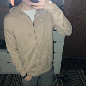 Beige hoodie från Tresanti - Säljer en stilren beige hoodie från Tresanti med dragkedja och huva. Tröjan är tillverkad i ett mjukt material och funkar till alla säsonger. Hör av dig om du har några frågor 😊 Nypris 1300 kr