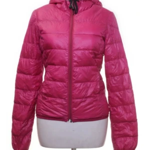 Rosa dunjacka från Zara - Säljer en snygg rosa dunjacka från Zara med dragkedja och huva. Jackan är perfekt för kyligare dagar och har en smidig passform. Den är tillverkad av 90% dun och 10% fjädrar för extra värme. 