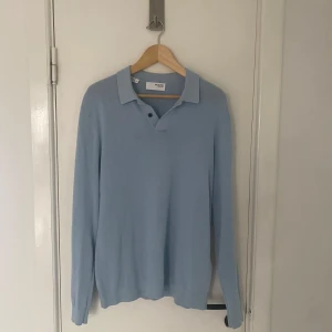 Ljusblå pikétröja från Selected Homme - Säljer en stilren ljusblå pikétröja från Selected Homme. Tröjan har långa ärmar och en klassisk krage med knappar framtill. Perfekt för en avslappnad men ändå snygg look. Skönt material också. Skriv om ni har några övriga frågor🙌