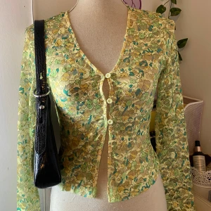 Blommig spetsblus från CIE - Säljer en vacker blommig spetsblus från cider. Blusen har långa ärmar och knappar framtill. Perfekt för att ge en romantisk touch till din outfit. 