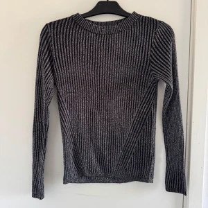 Svart och vit ribbad tröja från H&M - Säljer en stilren svart och vit ribbad tröja från H&M. (Katt och kanin finns i hemmet)