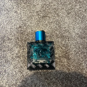 Säljer för jag använder aldrig den  - Säljer en flaska Versace Eros Eau de Toilette, 50 ml. Flaskan har en elegant blå design med det ikoniska Medusa-huvudet och gulddetaljer. Perfekt för den som vill ha en fräsch och maskulin doft.