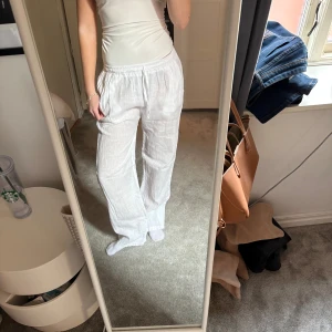 Vita linnebyxor med resårmidja - Snygga och bekväma vita linnebyxor med resår i midjan. Perfekta för en avslappnad stil. Byxorna har en luftig passform och är tillverkade på gotland och gjorda linne. Väldigt tunna och lite genomskinliga men beiga underkläder funkar fint. Dem är en s/m i storlek