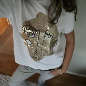 T-shirt med tryck -  Snyggt t-shirt från Sara med tryck som är guldigt / metall använd ett fåtal gånger, köpt här på Plick. Lånade bilder av hon jag köpte av, kommer tyvärr inte till användning💗