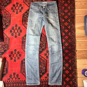 Blå jeans från Acne Jeans - Snygga blå jeans från Acne Jeans i modellen Hep Matrix. De har en klassisk femficksdesign och en knappgylf. Perfekta för en stilren look.