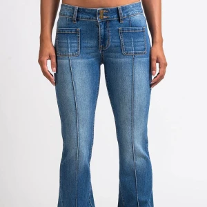 Blå bootcut jeans med fickdetaljer - Snygga blå bootcut jeans med låg midja och framträdande fickor fram och bak. Jeansen har bälteshällor och dekorativa. Jeansen är från madlady, fick dom i samarbete och har aldrig använt! Finns i flera färger! Storlek : 32/XS EXTRA SHORT I längden!