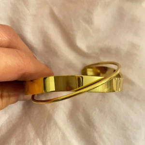 Guldarmband med flera band - Elegant guldarmband med flera tunna band som skapar en stilren och modern look. Perfekt för att ge en touch av glamour till din outfit. Armbandet har en öppen design som gör det enkelt att justera efter handleden.
