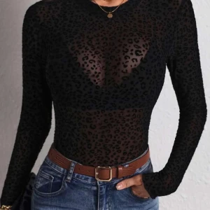 Svart leopardmönstrad mesh-topp - Snygg svart mesh-topp med leopardmönster. Den har en tight passform och långa ärmar, perfekt för en trendig look. Toppen är genomskinlig och ger en djärv stil.