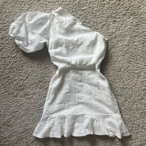 Vit miniklänning  - Så söt klänning med one shoulder och ett broderat blommönster💖Perfekt till student eller för sommarens alla tillfällen! 