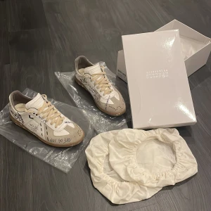 Vita maison margielas - Dom här maison margiela skorna kostar över 6000 nypris men jag säljer dom betydligt mycket billigare. Dom är i storlek 43 men dom skulle även kunna passa 42. Dom var för små för mig därför jag säljer dom och behöver pengar snabbt därför det låga priset. Box och tillbehör ingår. Skick 9.5/10 knappt använda. Hör av er vid frågor🙌