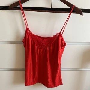 Somrigt mjukt spets linne - Snygg röd linnetopp med tunna axelband och vacker spetsdetalj vid halsringningen. Mjukt material och jätte söt