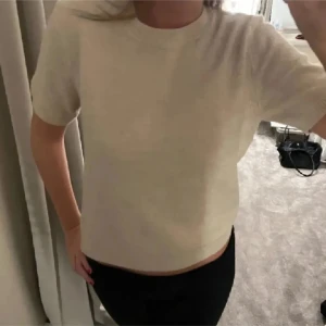 Beige kortärmad tröja - Säljer en stilren beige tröja med korta ärmar. Perfekt för en avslappnad look. Tröjan har en enkel design och är lätt att matcha med olika outfits.
