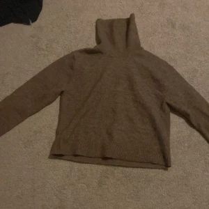 Brun polotröja från Weekday - Säljer en stilren brun polotröja från Weekday. Tröjan är stickad och har långa ärmar, perfekt för kyligare dagar. Den har en klassisk design med ribbade kanter vid ärmslut och nederkant.