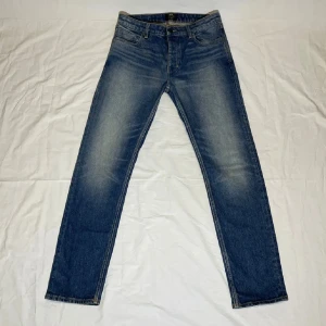 neuw straight - Snygga blå jeans med rak passform och klassisk design. De har en bekväm midja och är perfekta för en avslappnad stil. Jeansen har en lätt tvättad look och fem fickor. 32/32