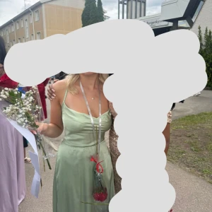 Ljusgrön klänning med smala axelband - Elegant ljusgrön silkes klänning med smala axelband och slitt. Den går ner till golvet och har en fin snörning i bak. Perfekt till skolavslutning och bal. Skriv om de är några frågor eller vill ha fler bilder💕💕Den är använd 1 gång