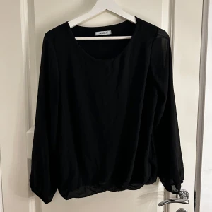 Svart långärmad topp från Vero Moda - Säljer en stilren svart långärmad topp från Vero Moda. Toppen har en rund halsringning och är tillverkad i ett mjukt material som ger en bekväm passform. Perfekt för att matcha med olika outfits. Hör av dig vid intresse!