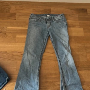 Blå jeans med broderade detaljer low waist bootcut  - Snygga blå jeans med broderade detaljer på bakfickorna. De har en klassisk femficksdesign och en bekväm passform. Perfekta för en avslappnad stil.