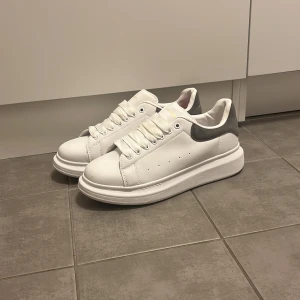  Alexander McQueen skor  - Snygga vita sneakers från Alexander McQueen som är riktigt unika och fina om man ska på någon speciell tillfälle, dem har aldrig använts heller att  någon annan använder dem än att dem ligger och ruttnar jag säljer dem även för dem är för stora för mig. Skorna har en chunky sula och klassisk snörning. Perfekta för en stilren look. Kontakta mig om pris eller funderingar för en snabba affär.
