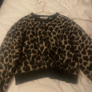 Leopardmönstrad tröja från NA-KD - Säljer en snygg leopardmönstrad tröja från NA-KD. Tröjan har en cool design med långa ärmar och en mjuk känsla. Perfekt för att ge din outfit en trendig touch. 🐆