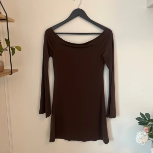 Offshoulder klänning från BikBok storlek S - Säljer en brun långärmad klänning som är offshoulder från BikBok med rundad halsringning och figurnära passform. Klänningen är enkel och stilren, perfekt för dig som gillar minimalistisk stil. Skönt och stretchigt material. Använd endast en gång! Köpt för 399kr. 