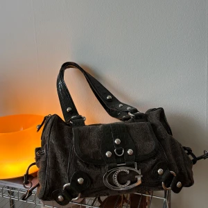 Grön axelväska - Cool svart axelväska från gussaci med stora silvriga detaljer och ett stort C-spänne framtill. 