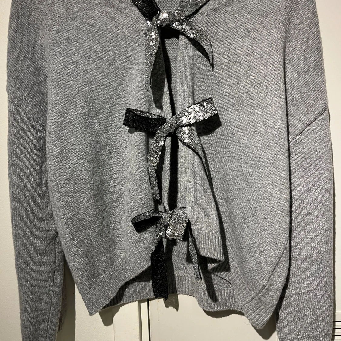 Grå stickad tröja med glittriga rosetter