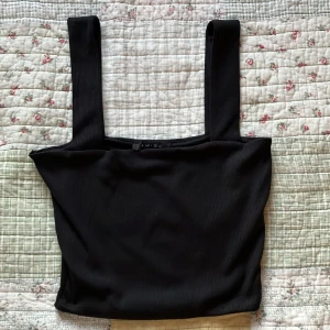 Svart ribbad linnetopp från Amisu - Nästan aldrig andvänd. Köpte den 2021, 2021 passade den inte på mig,banden var för långa då. Har aldrig andvändt mer än att prövat nån gång för 4 år sedan. den är svart ribbad linnetopp från Amisu/Gina Tricot.          