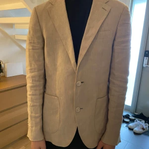 THESE GLORY DAYS Linne Kavaj - Säljer en stilren linnekavaj, perfekt för vår- och sommarsäsongen. Kavajen är tillverkad av högkvalitativt linne och erbjuder både komfort och elegans.