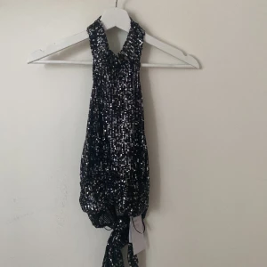 Paljettopp med öppen rygg - Jättefin paljettopp med öppen rygg som tyvärr inte passar mig. Dessutom oanvänd, prislappen sitter kvar