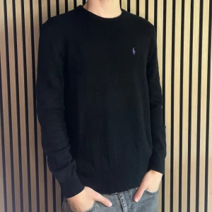 Ralph Lauren sweater - Ralph Lauren sweater. Tröjan är svart och av lammull. Skicket är bra men tröjan har blivit lagad en gång som man ser på bilden. Storlek M. 