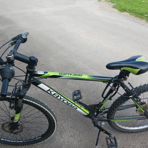 Rockland - En sportig mountainbike från Kayoba, perfekt för dig som gillar äventyr och fart. Cykeln har robust ram, grova däck och cool grön-svart design. Passar både till vardags och för tuffare terräng. Gör dig redo för nya cykelupplevelser!